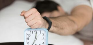 Άνθρωπος στο κρεβάτι με ρολόι