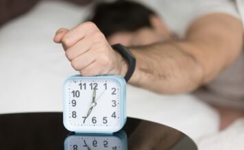 Άνθρωπος στο κρεβάτι με ρολόι