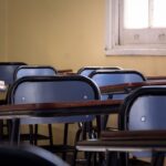 Άδεια σχολική αίθουσα με θρανία και καρέκλες δίπλα σε παράθυρο