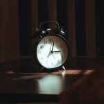 Κοιμάσαι στις 2, ξυπνάς στις 6: Το χρέος ύπνου που πληρώνει το σώμα σου Ξυπνητήρι σε ξύλινο τραπέζι τη νύχτα, φωτογραφία Suhas Hanjar / Unsplash