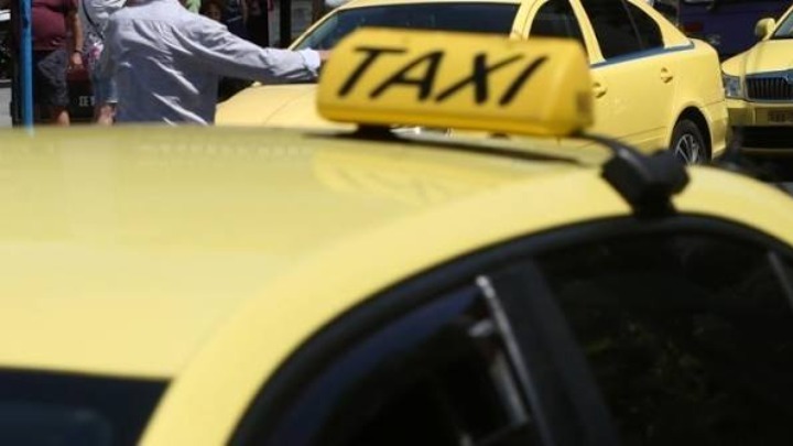 Κίτρινο ταξί σε δρόμο της πόλης τη νύχτα